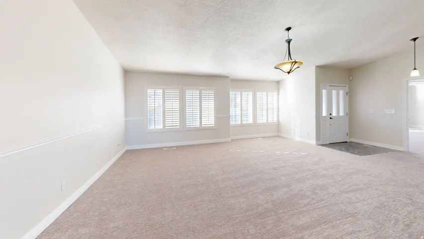 Unfurnished room featuring light colored carpet and a textured ceiling