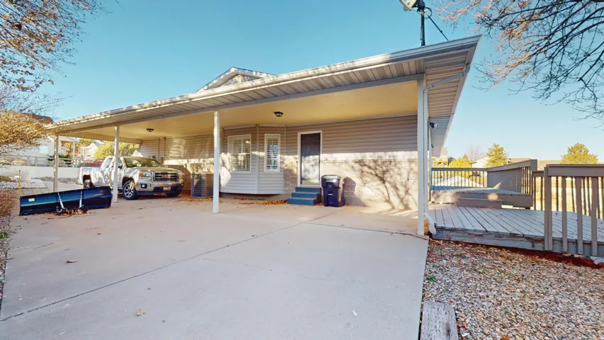 Rear view of property featuring a carport and a deck