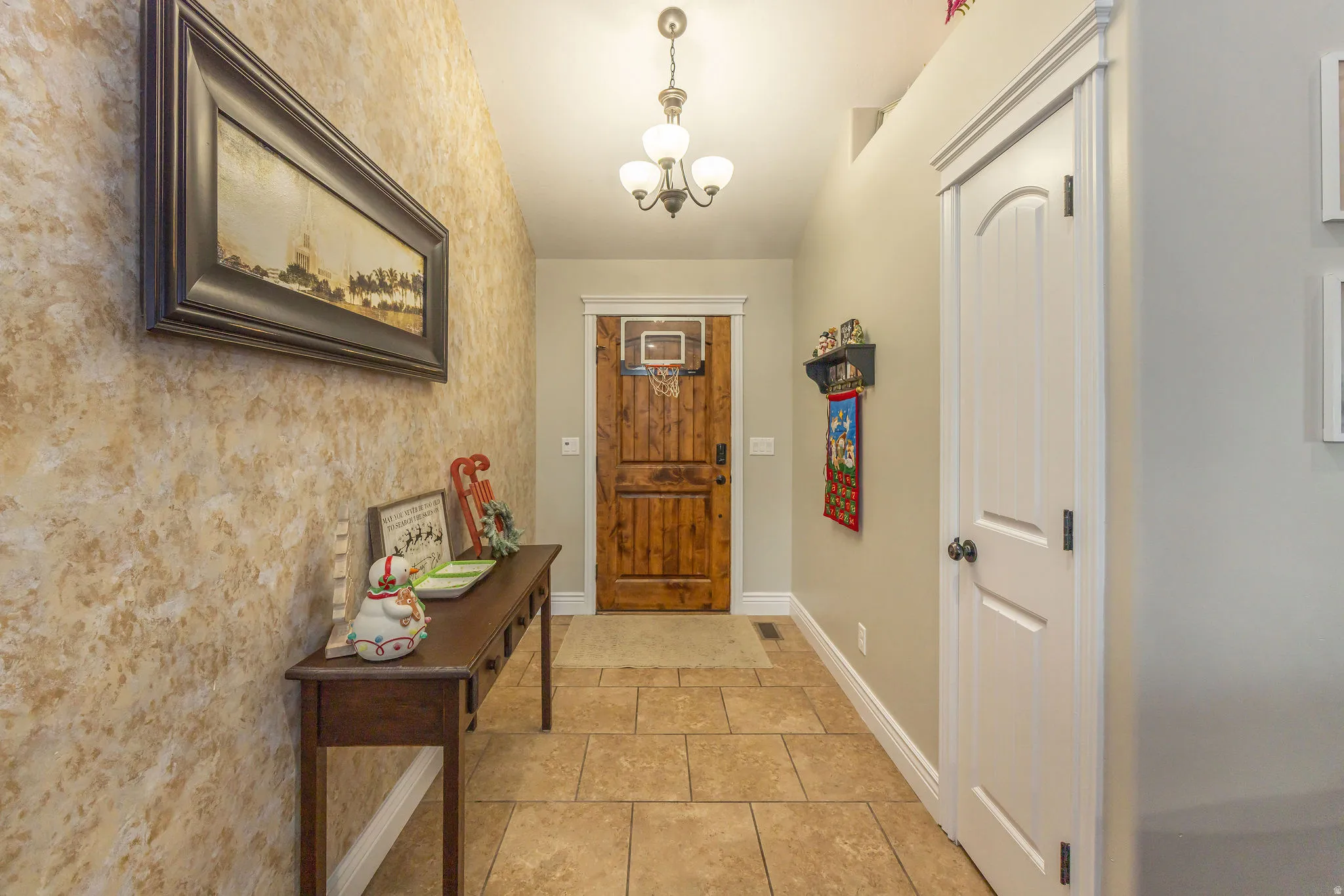 Entryway with a chandelier and tile patterned floors