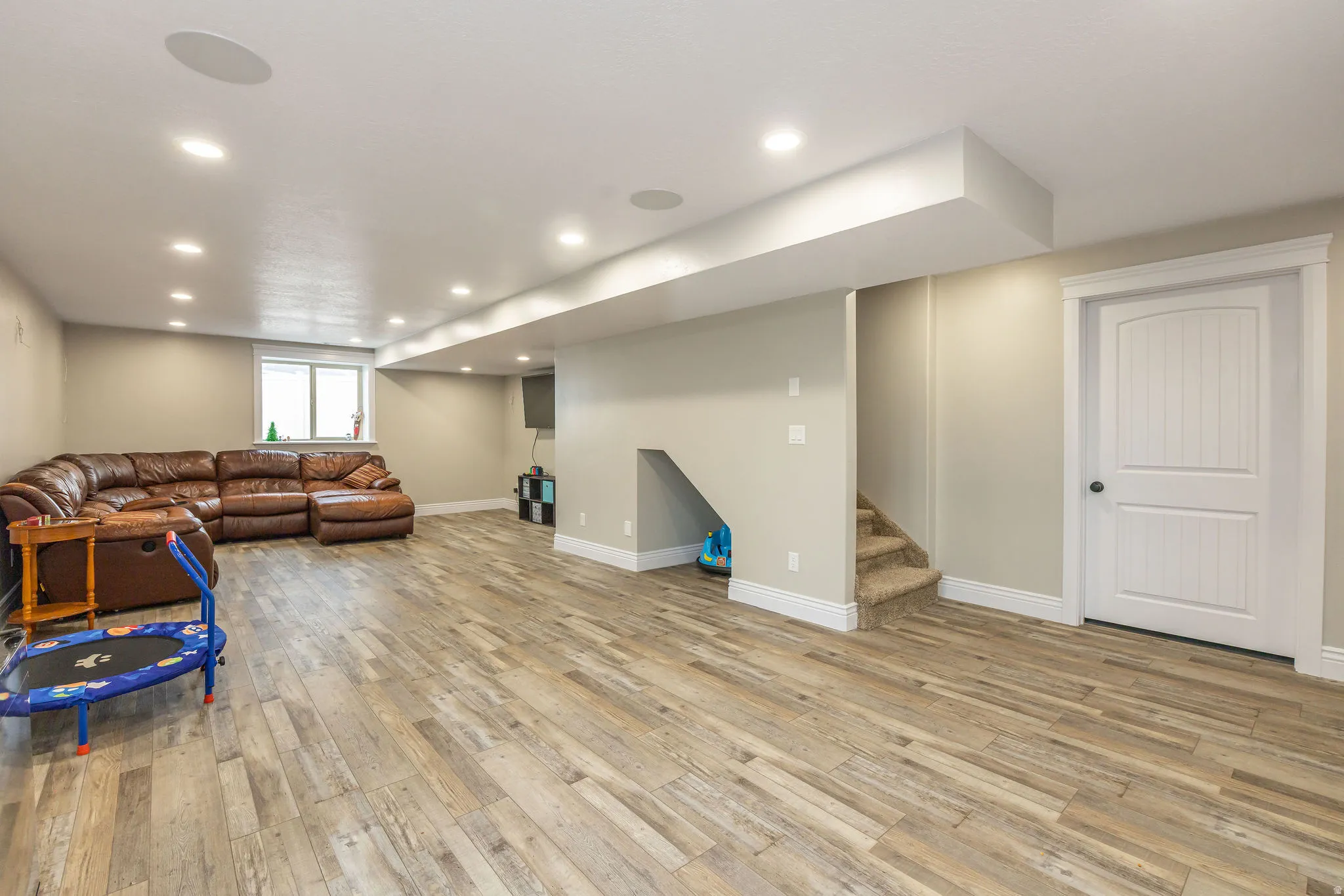 Living room featuring stairway, light wood finished floors, and recessed lighting