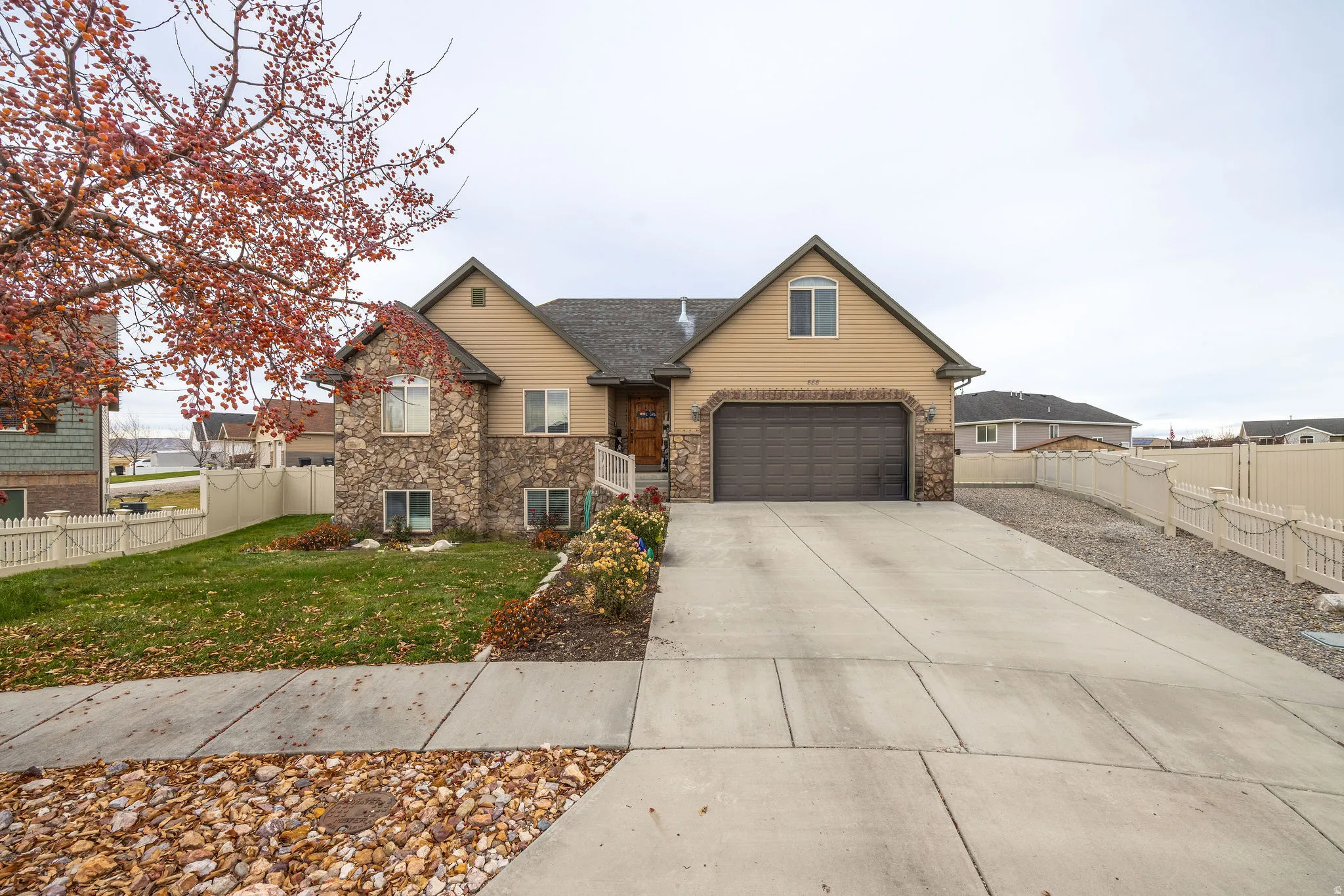 Traditional-style home with stone siding, concrete driveway, and a garage
