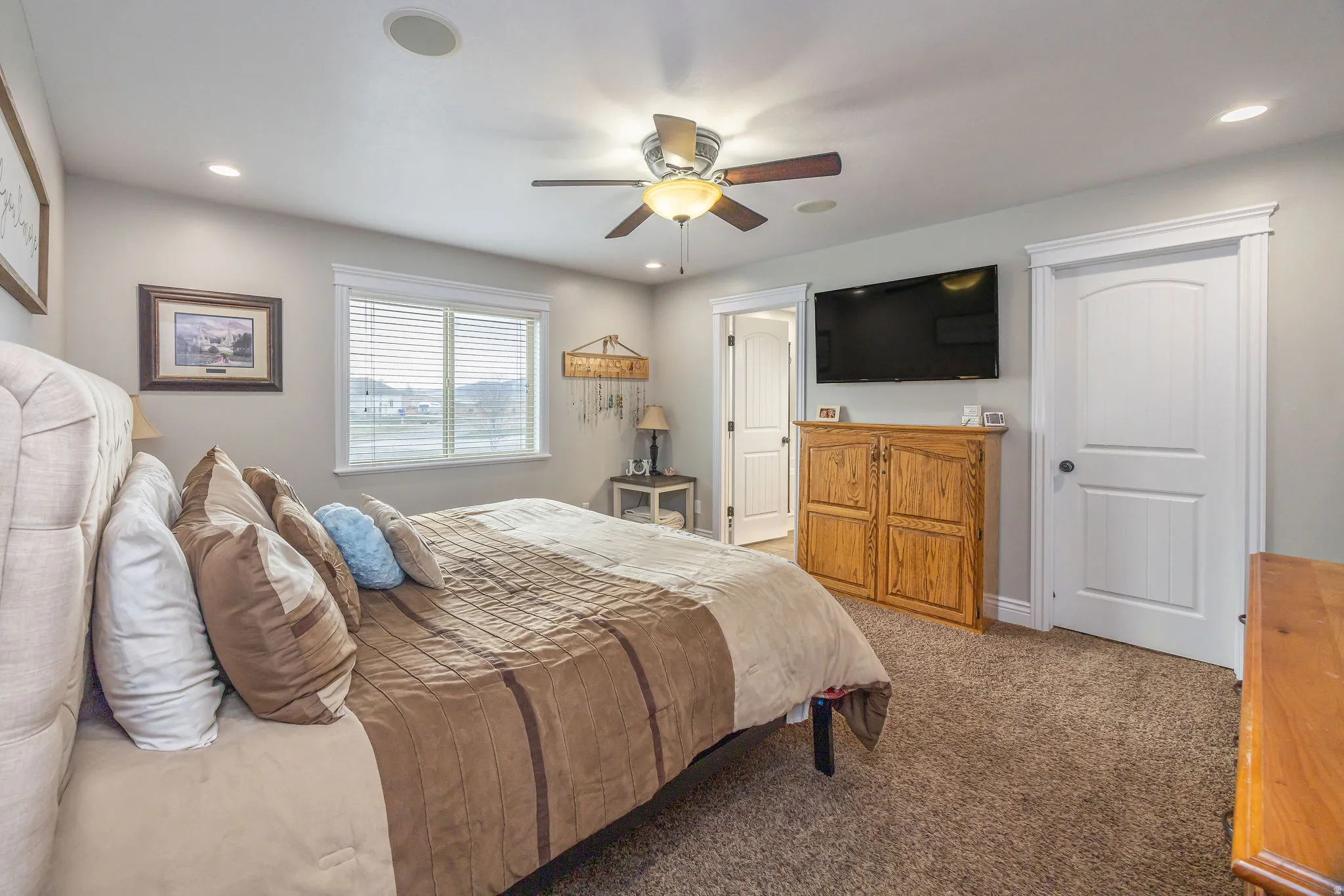 Bedroom with light carpet, ceiling fan, and recessed lighting
