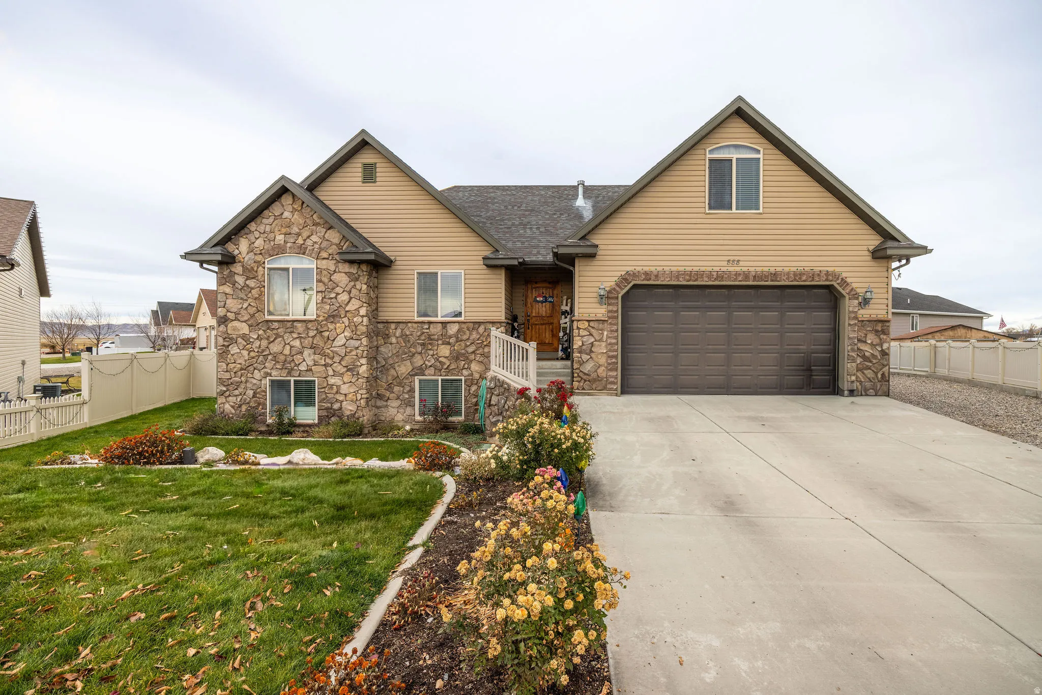 Traditional home with stone siding, concrete driveway, and a garage