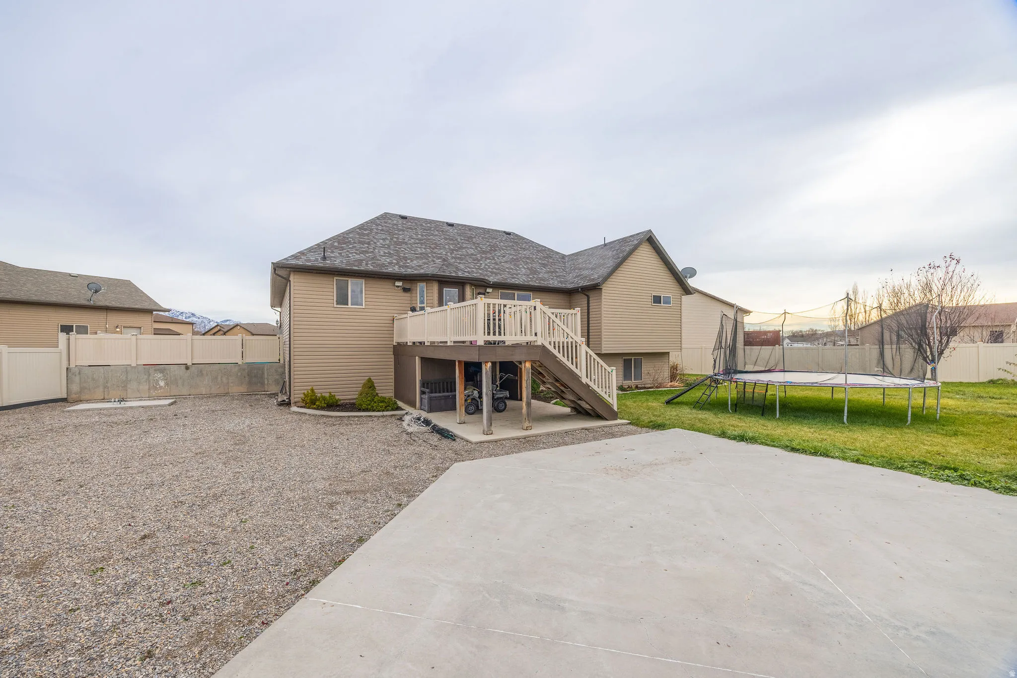 Back of property featuring stairway, a patio area, a trampoline, and a deck