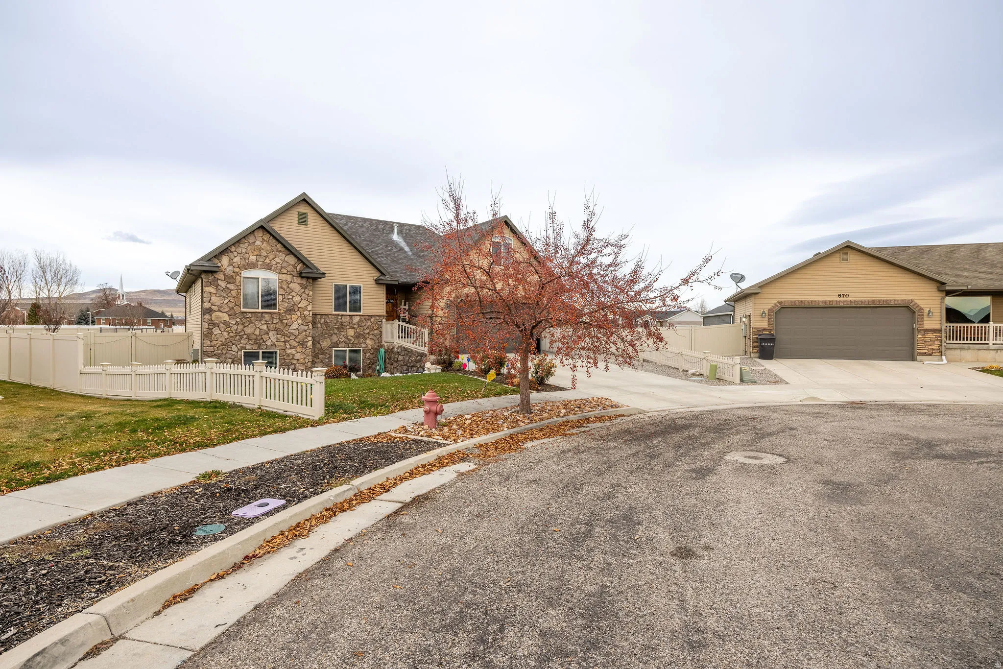 View of front facade featuring stone siding, concrete driveway, and a garage