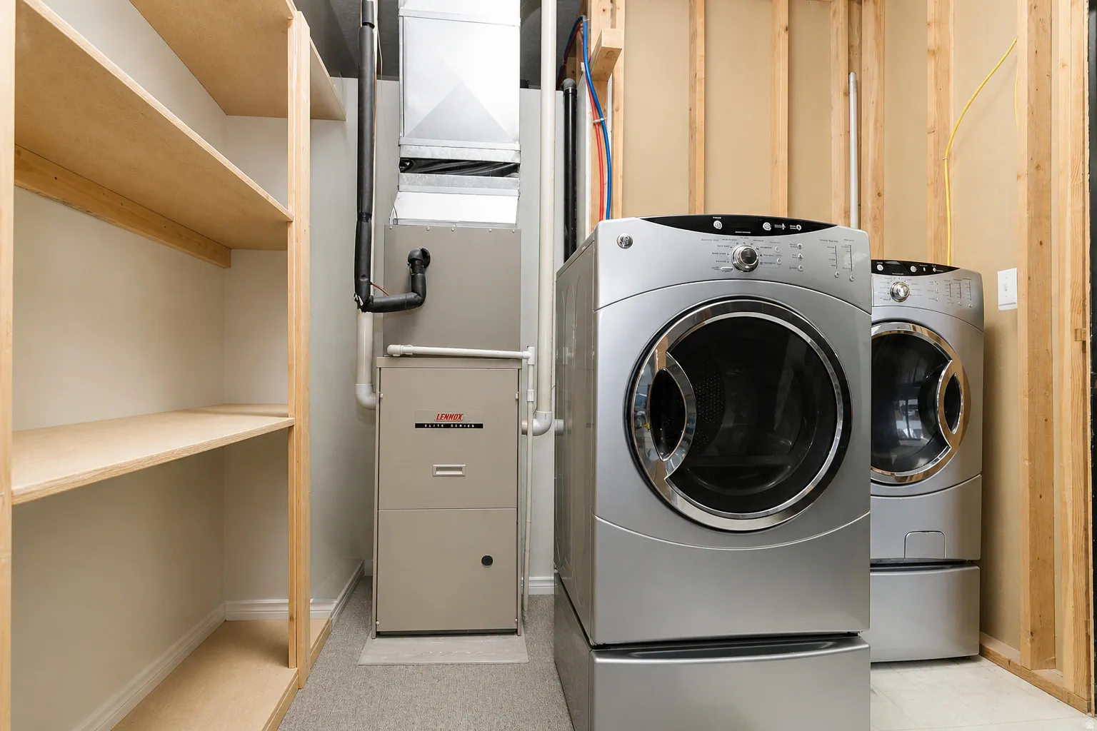 Laundry area featuring heating unit and baseboards
