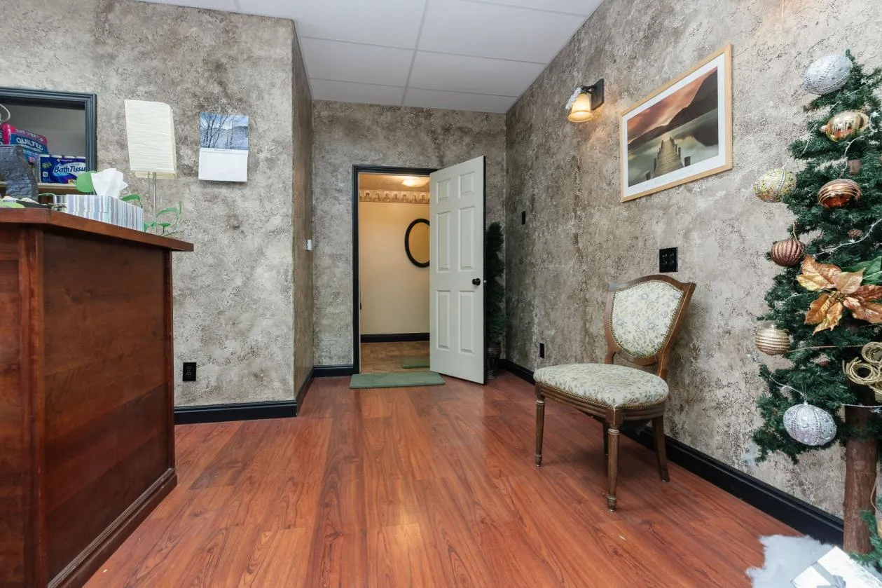 Hallway featuring a drop ceiling and dark wood-style flooring