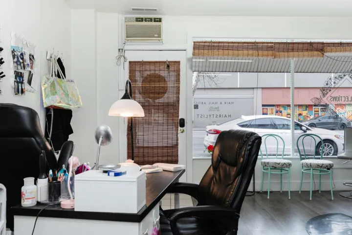 Office space with wood finished floors and a wall unit AC