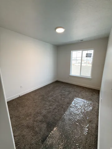 Carpeted empty room with baseboards and a textured ceiling