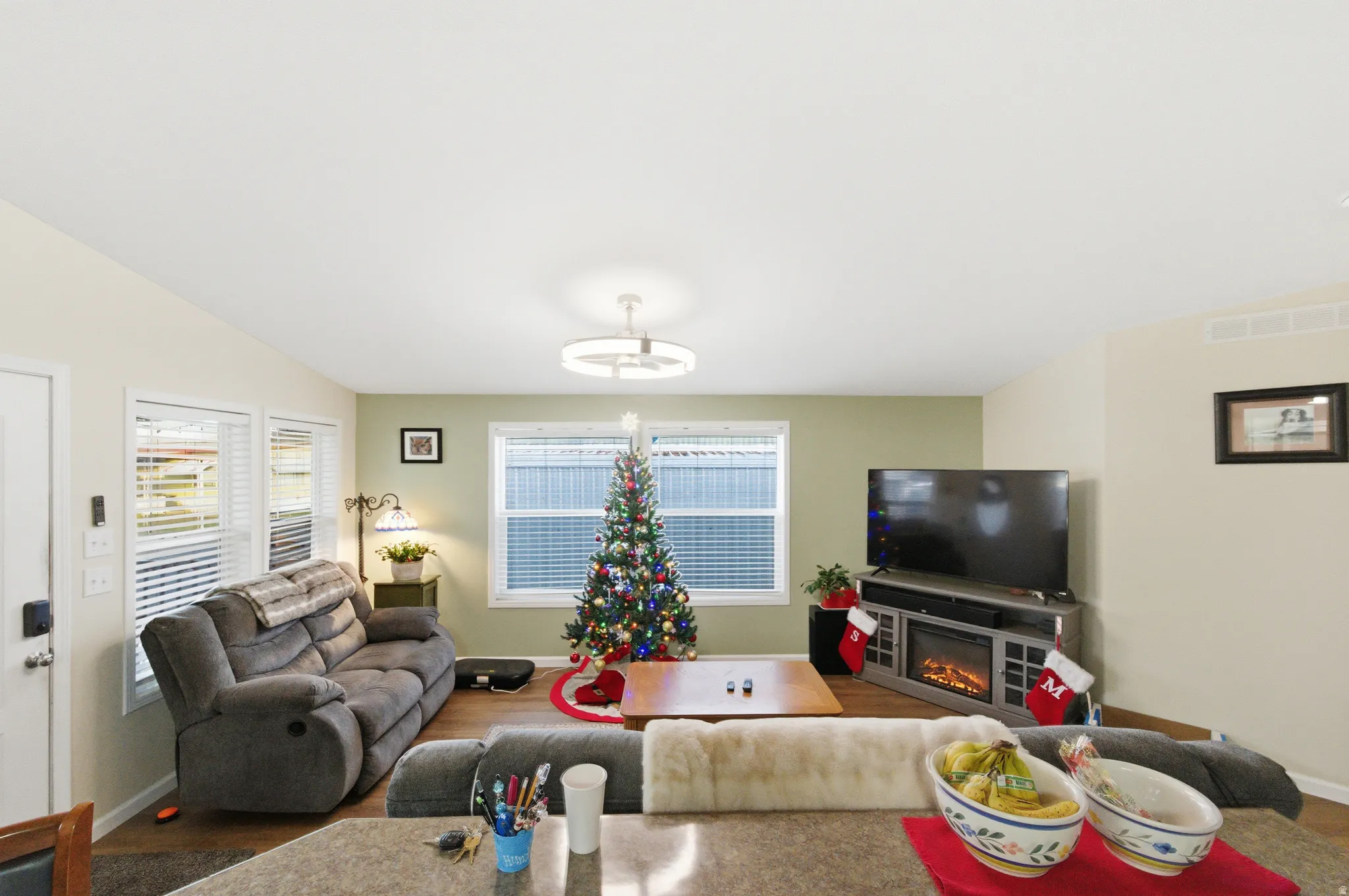Living room with wood finished floors and a glass covered fireplace