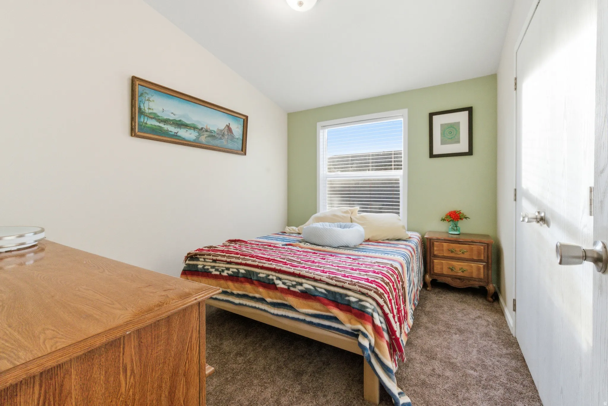 Bedroom featuring lofted ceiling and dark carpet