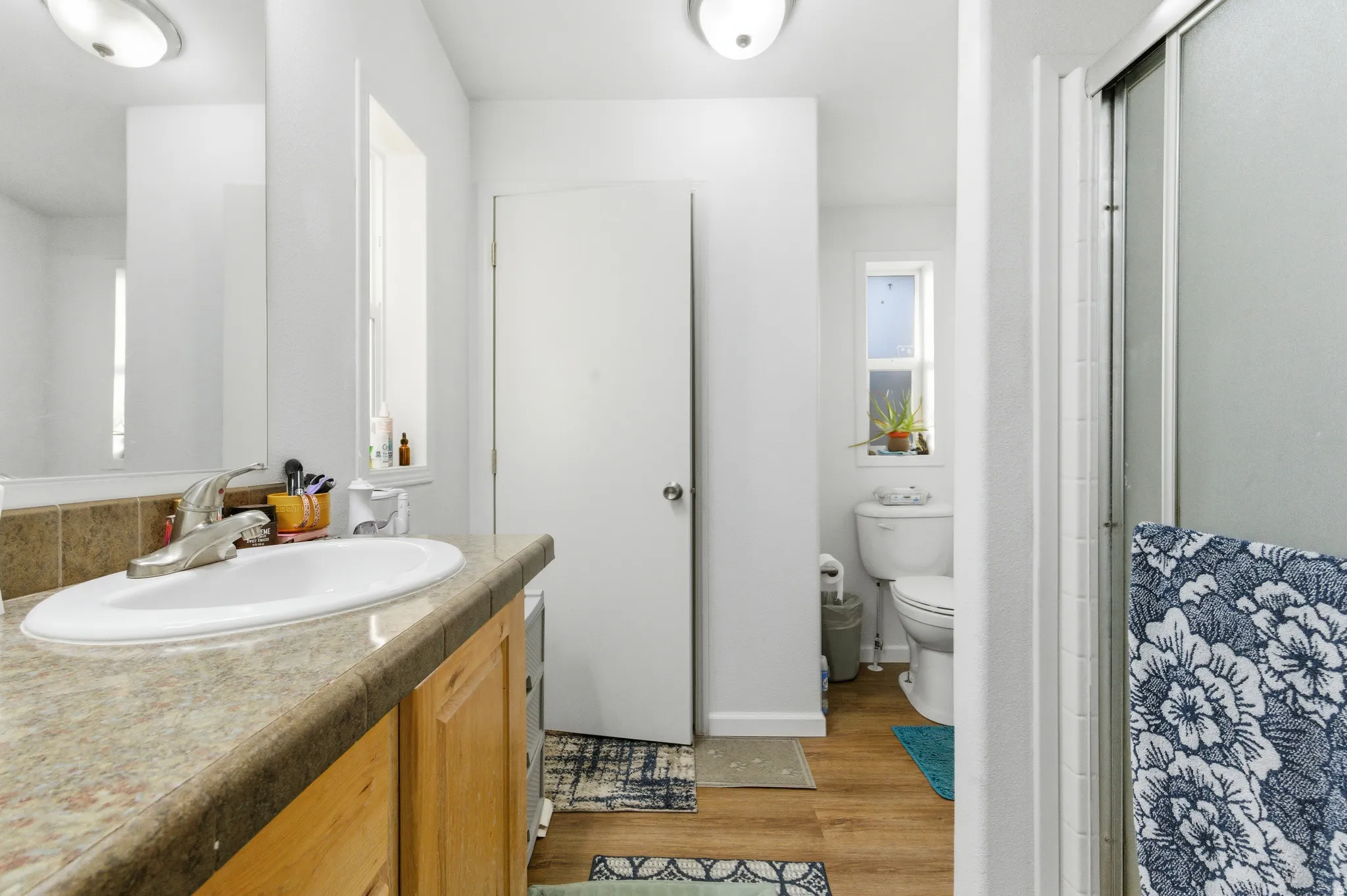 Bathroom featuring vanity, light wood finished floors, and a stall shower