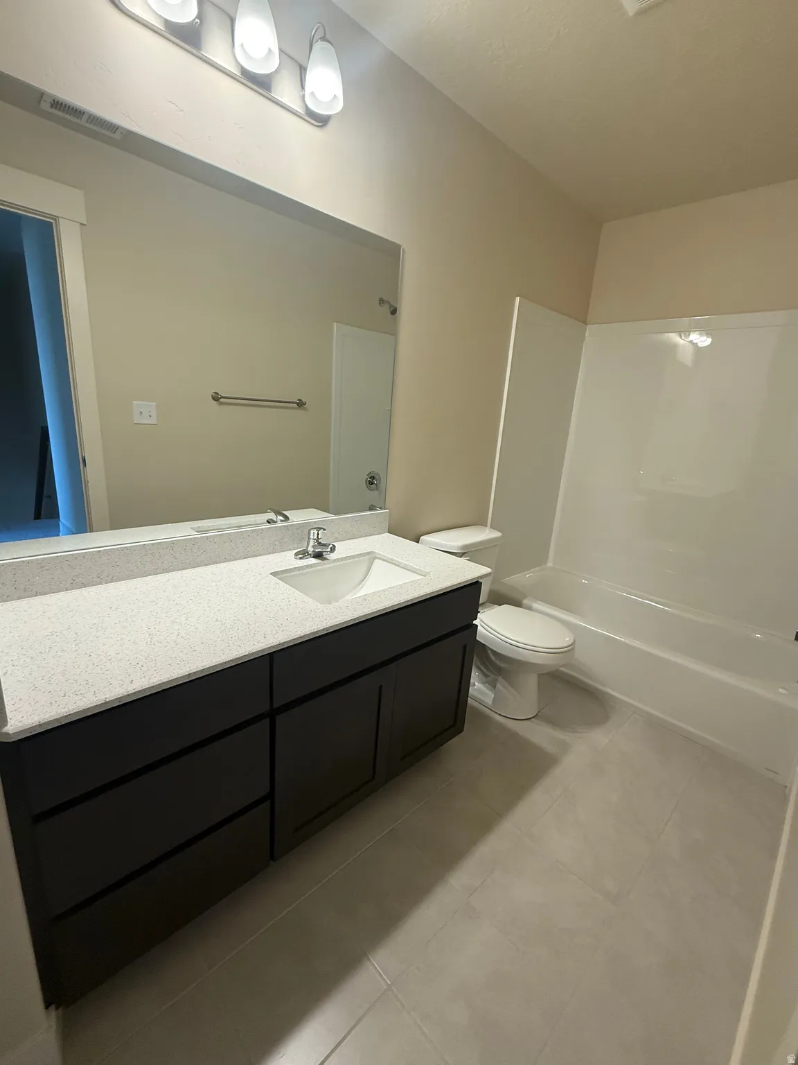Bathroom featuring vanity, light tile patterned floors, and shower / tub combination