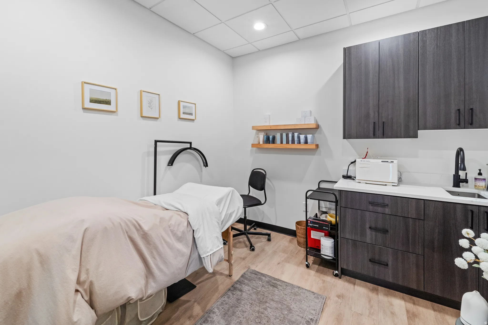 Bedroom with light wood-style flooring and a paneled ceiling