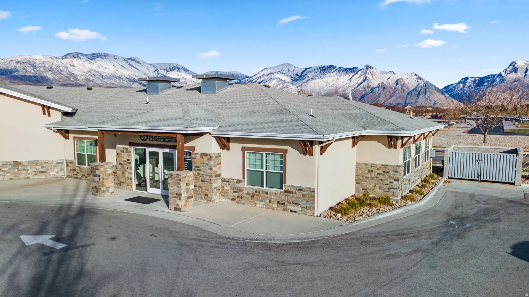 View of front facade featuring a mountain view, stone siding, stucco siding, and french doors
