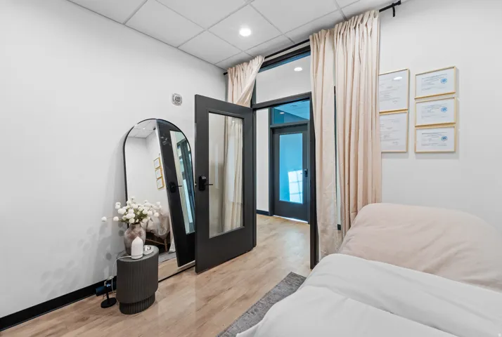 Bedroom with a drop ceiling, wood finished floors, and recessed lighting