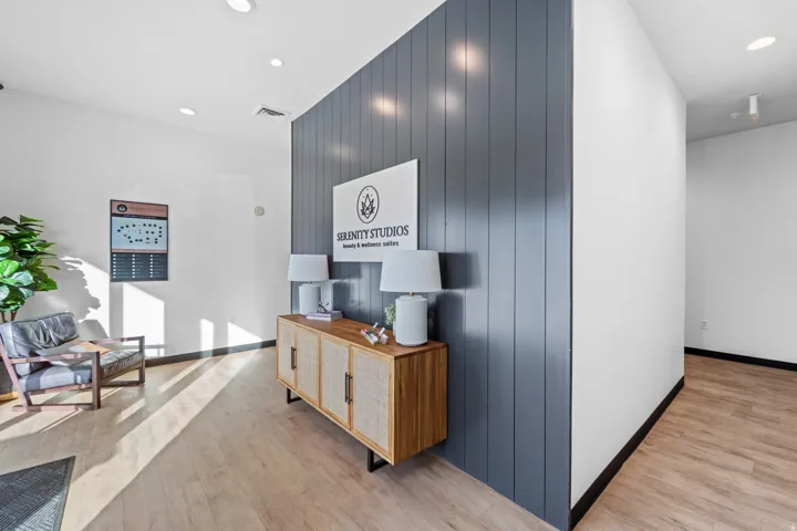 Hallway with recessed lighting, light wood finished floors, an accent wall, and wood walls