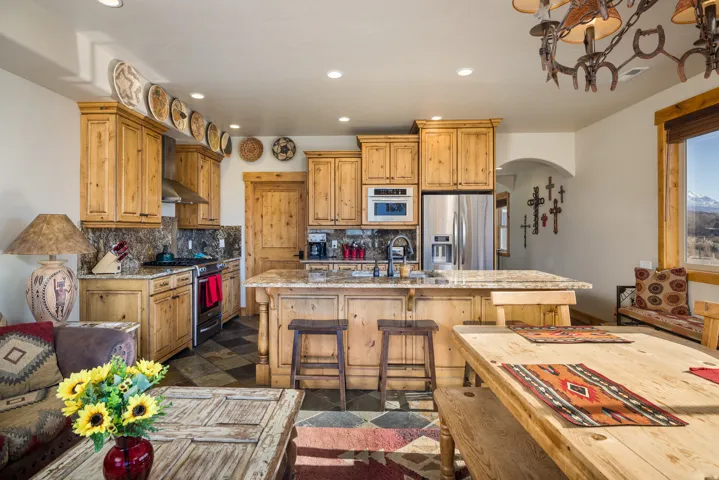 Kitchen featuring arched walkways, recessed lighting, stainless steel appliances, a kitchen bar, and tasteful backsplash