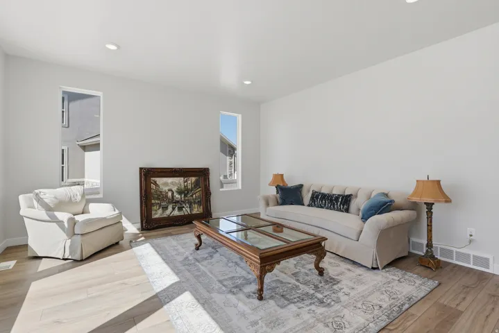 Living area with light wood finished floors and recessed lighting