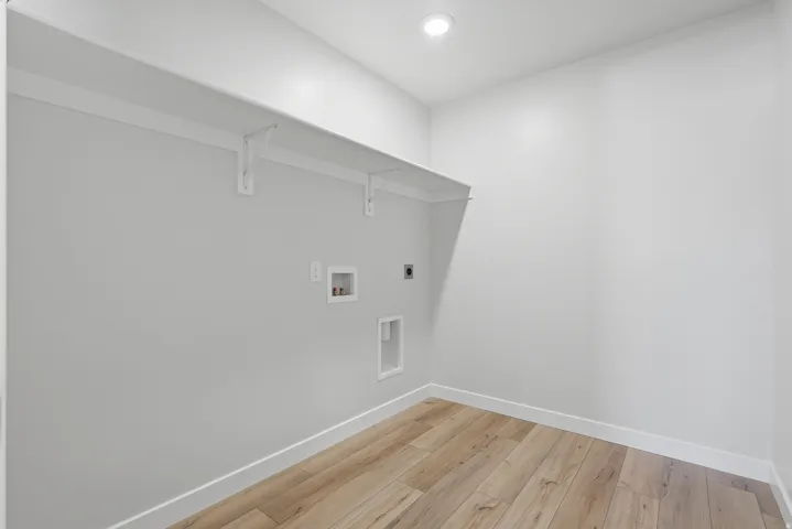 Laundry area with light wood finished floors, electric dryer hookup, hookup for a washing machine, and recessed lighting