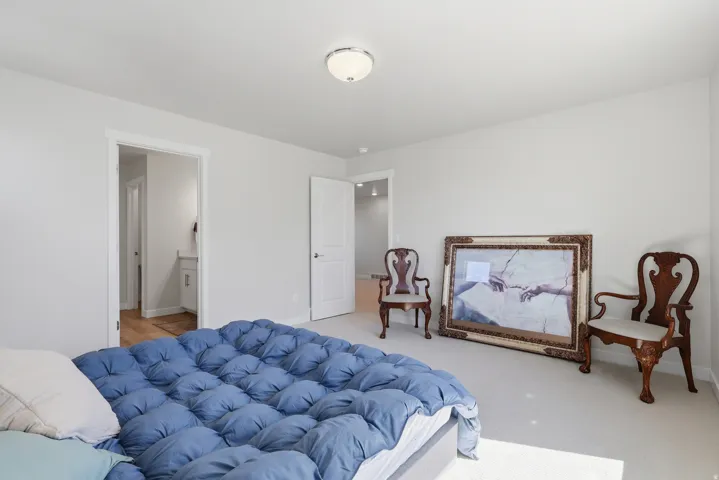 Primary Carpeted bedroom featuring connected bathroom and baseboards