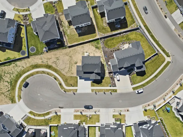 Aerial view of property and surrounding area featuring nearby suburban area