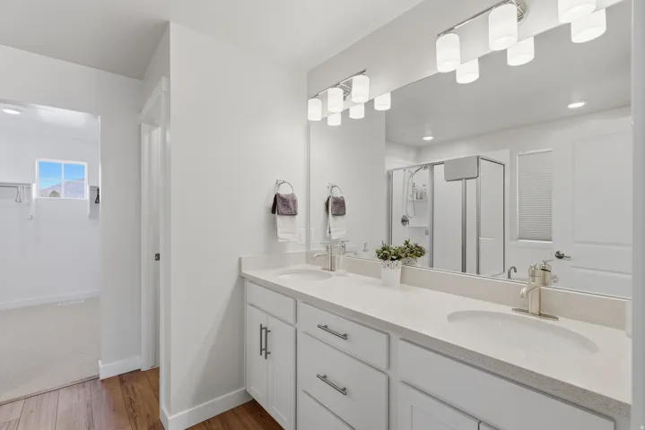 Primary Suite Full bathroom featuring double vanity, a stall shower, dark wood-type flooring, and recessed lighting