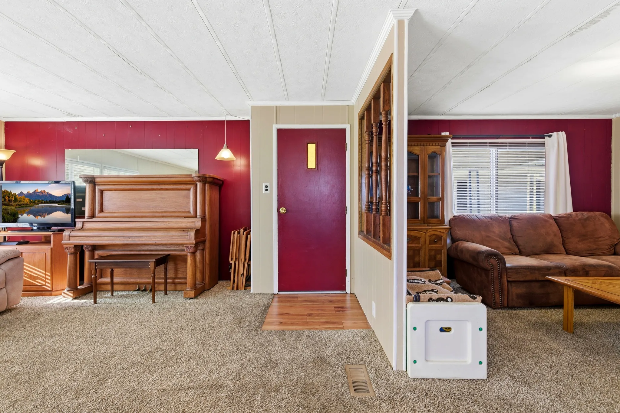 Living area with healthy amount of natural light, carpet, and crown molding
