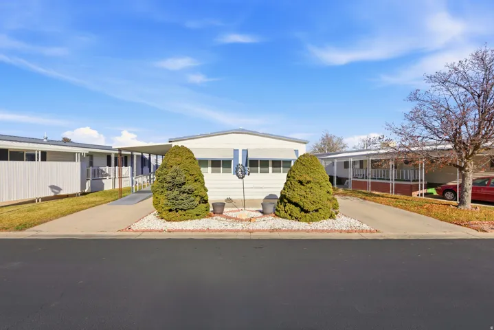Manufactured / mobile home featuring a carport and driveway