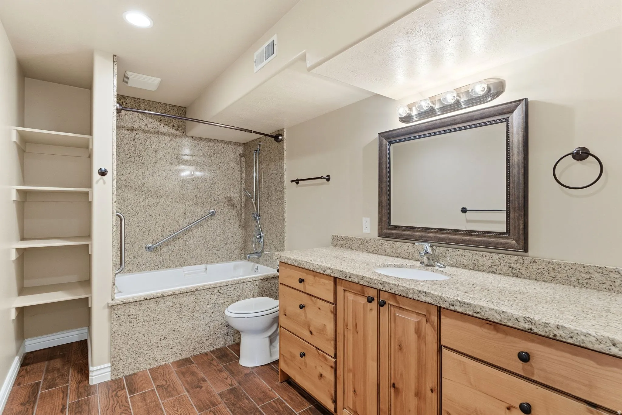 ADU Bathroom featuring vanity, wood finish floors, shower / bath combination tall counters and grab bars