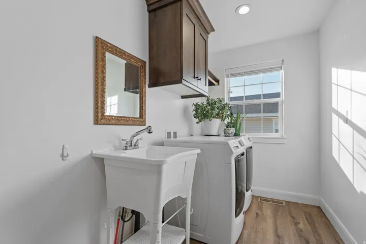 Laundry room with cabinet space, light wood finished floors, and independent washer and dryer