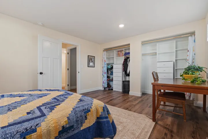Bedroom with dark wood-type flooring, two closets, and recessed lighting