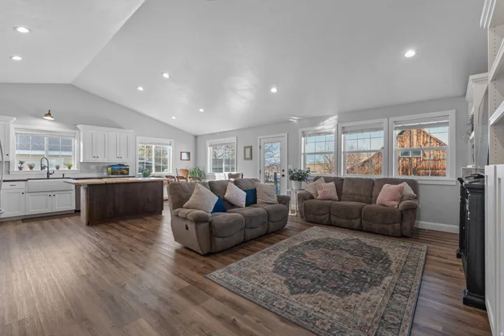 Living room with vaulted ceiling, dark wood finished floors, and recessed lighting
