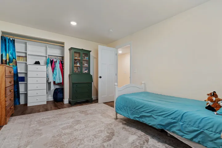 Bedroom with dark wood-style flooring, a closet, and recessed lighting