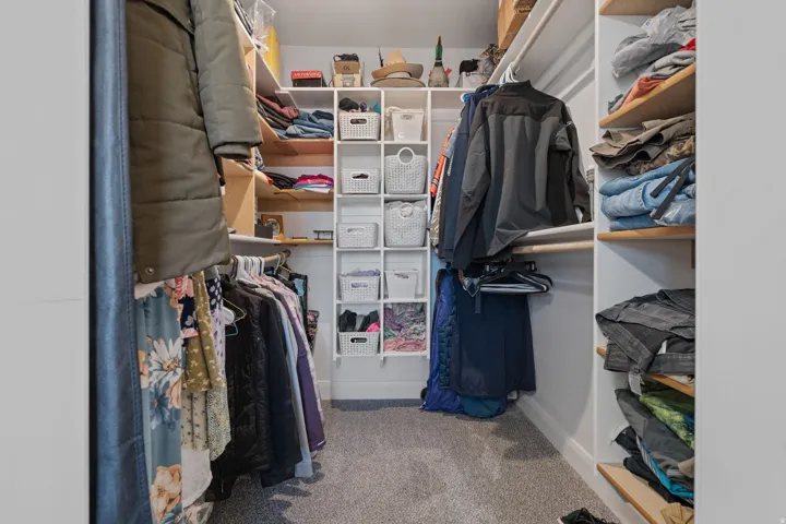 Spacious closet featuring light colored carpet