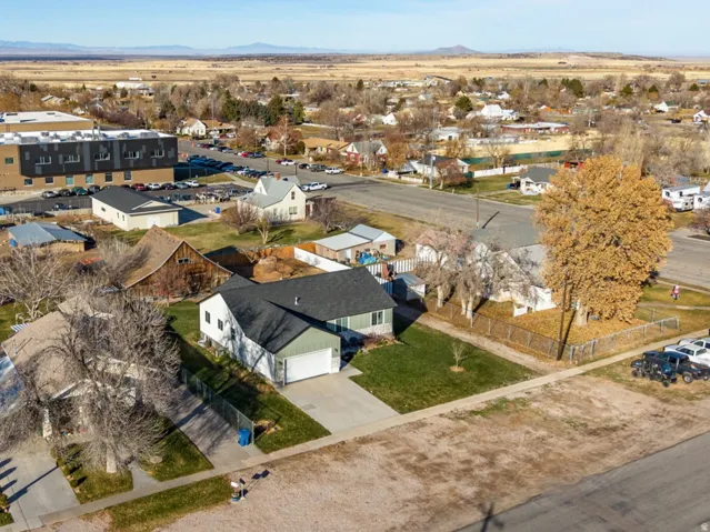 Aerial view of property and surrounding area featuring nearby suburban area and mountains