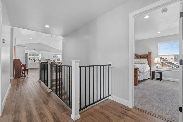 Hallway, recessed lighting, dark wood-style floors, and an upstairs landing