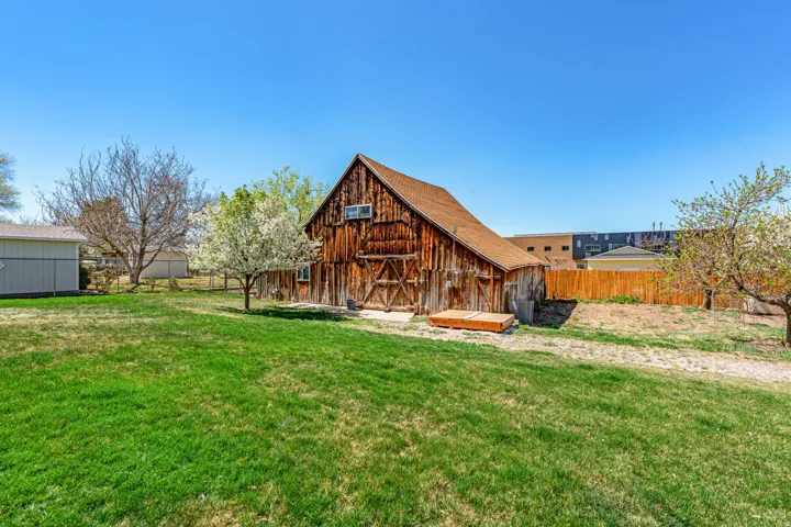 Rear view of property with an outdoor structure and a barn