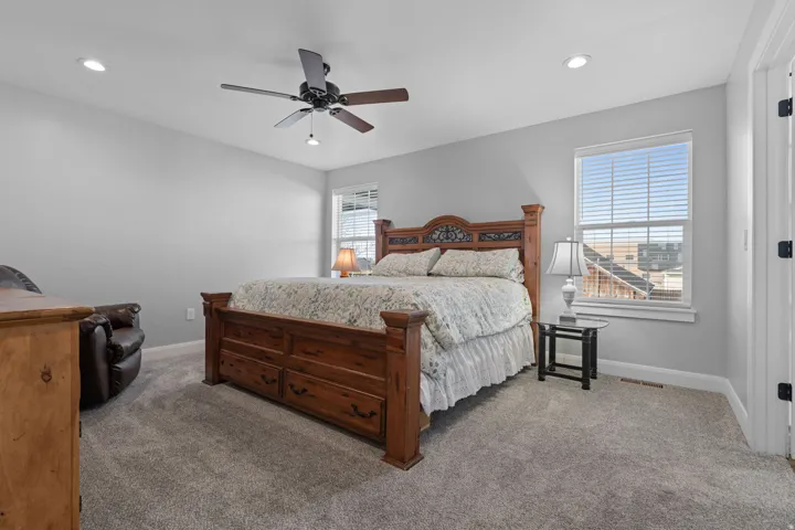 Carpeted bedroom featuring ceiling fan and recessed lighting