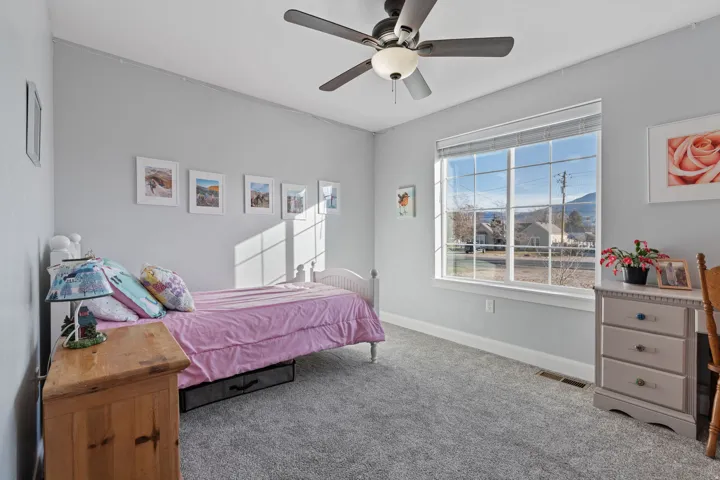 Carpeted bedroom with baseboards and a ceiling fan