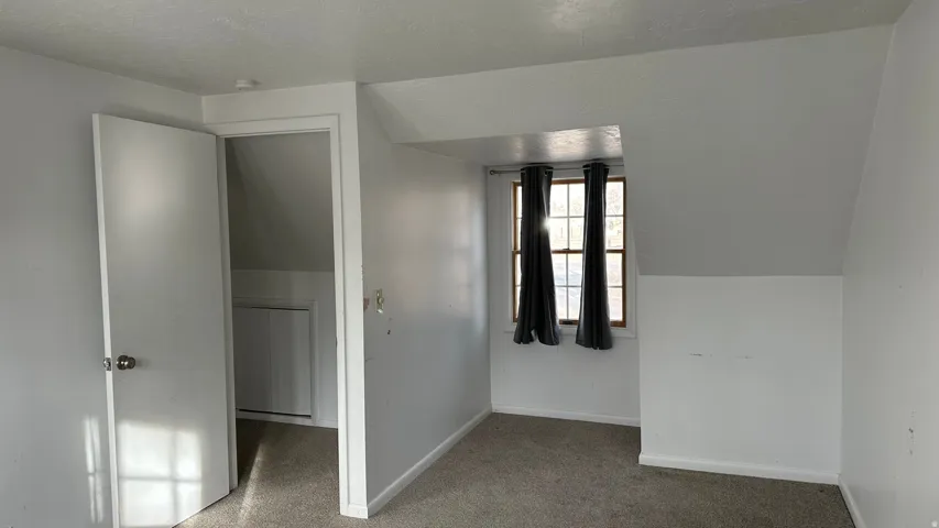 Hallway featuring a textured ceiling and lofted ceiling