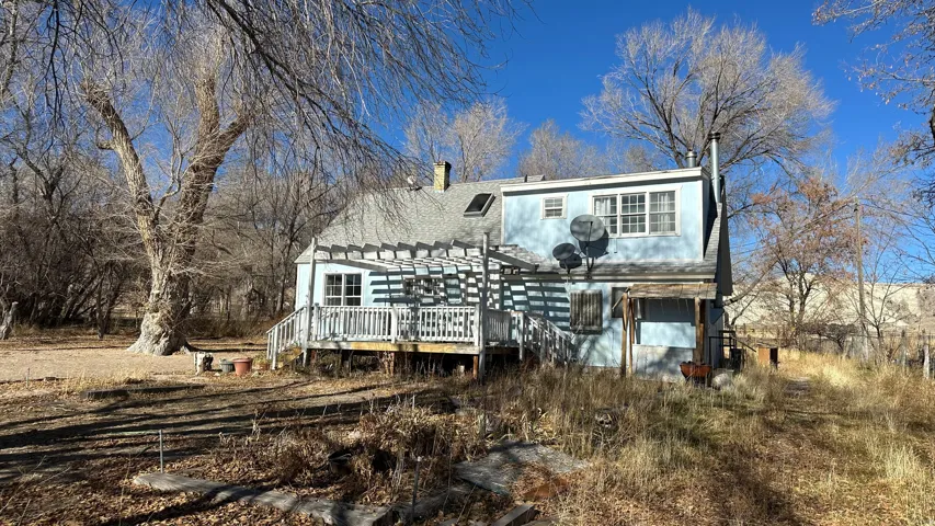 Rear view of property with a wooden deck, a pergola, and a chimney
