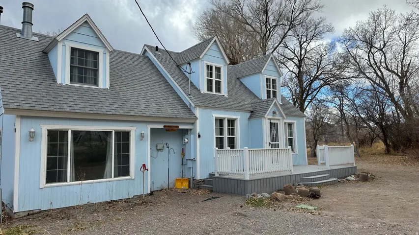 View of front of home featuring a deck and roof with shingles