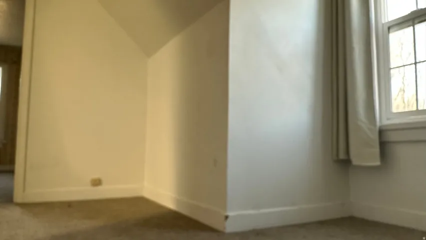 Carpeted spare room with baseboards