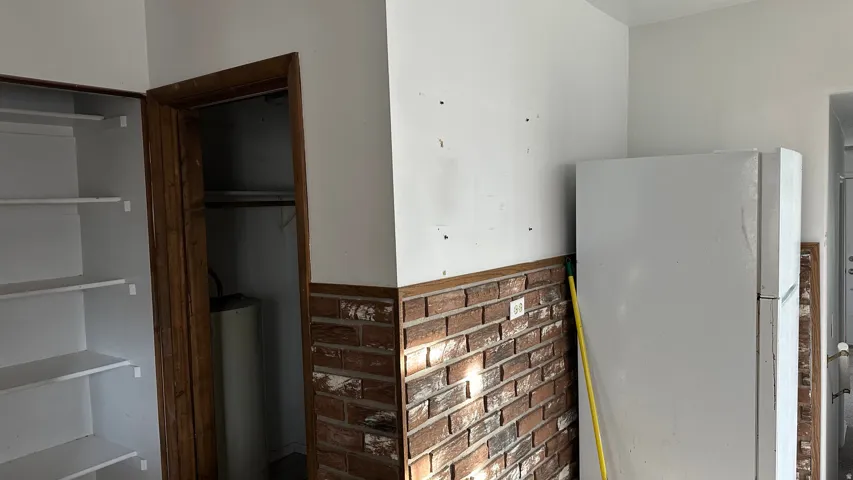 Kitchen view of freestanding refrigerator and water heater