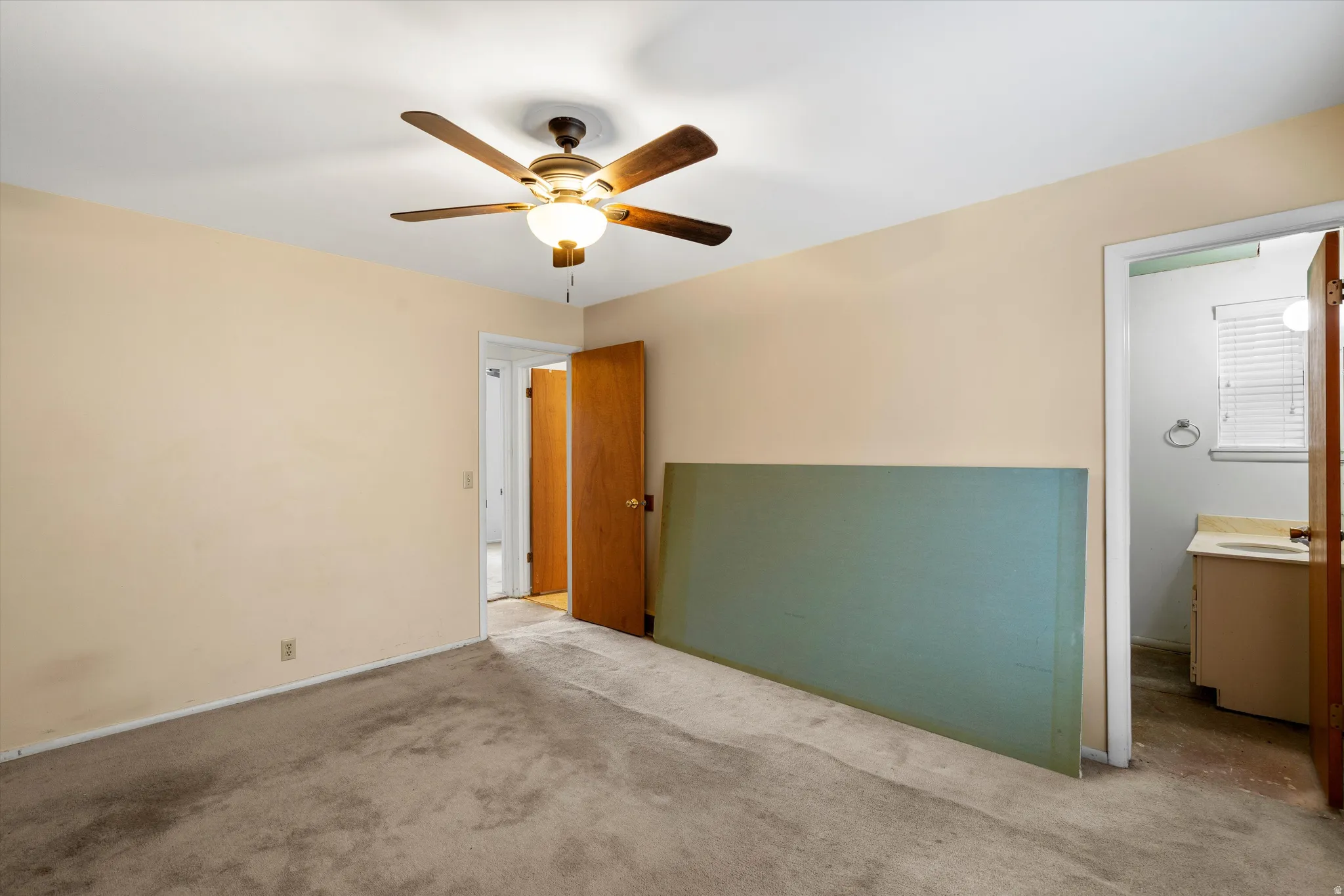 Unfurnished bedroom with a ceiling fan and carpet floors