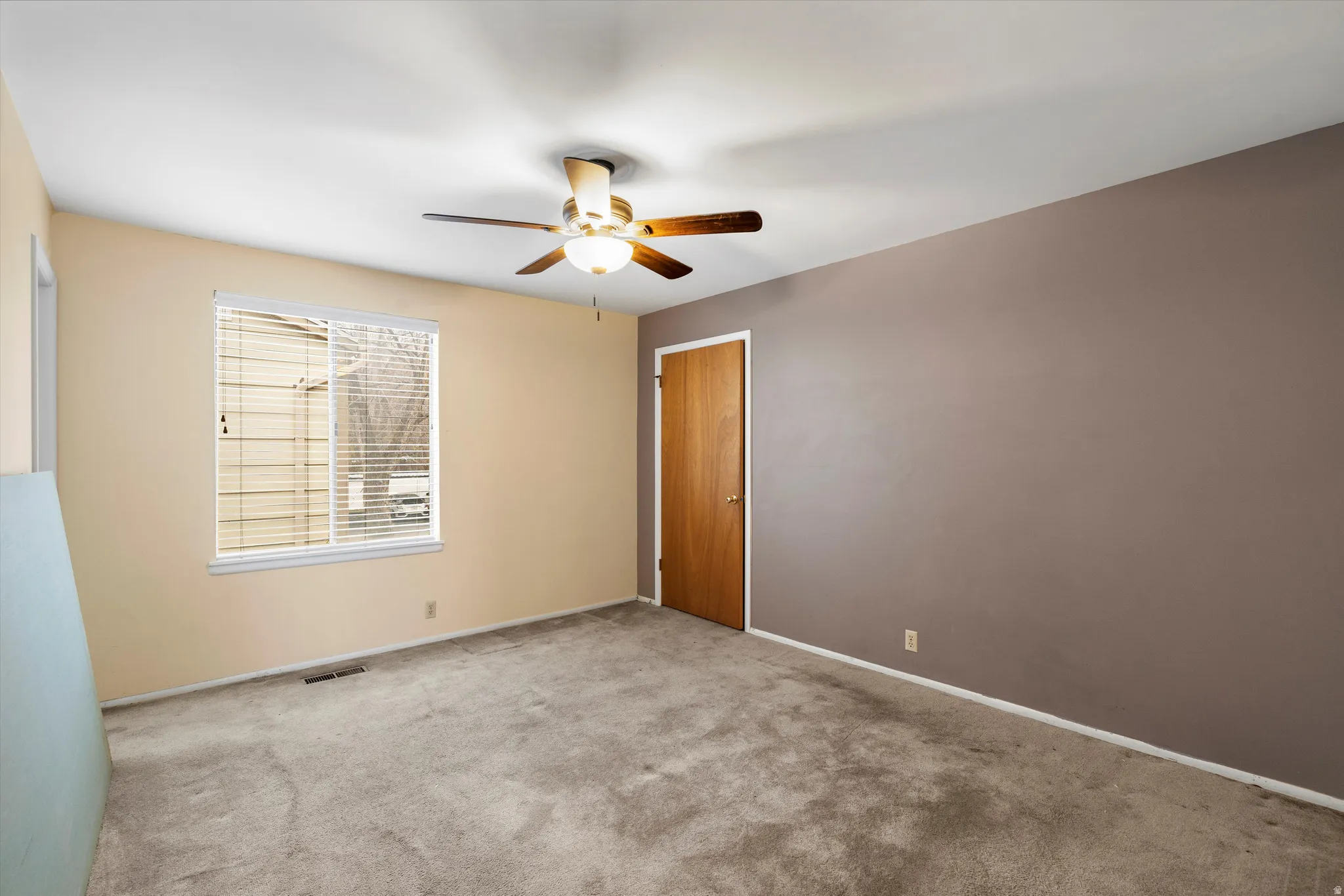 Carpeted empty room with baseboards and ceiling fan
