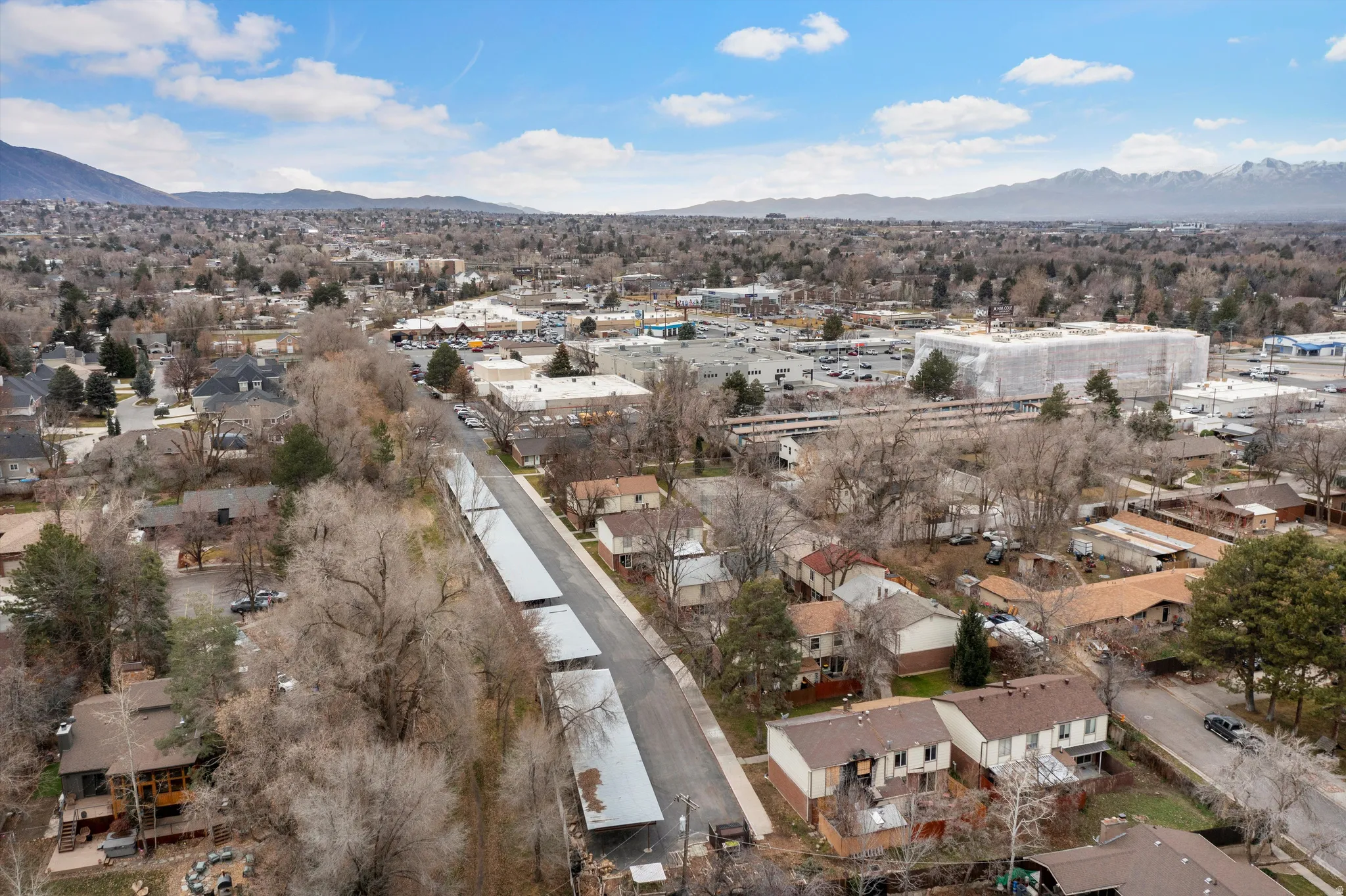 Aerial view of property and surrounding area featuring nearby suburban area