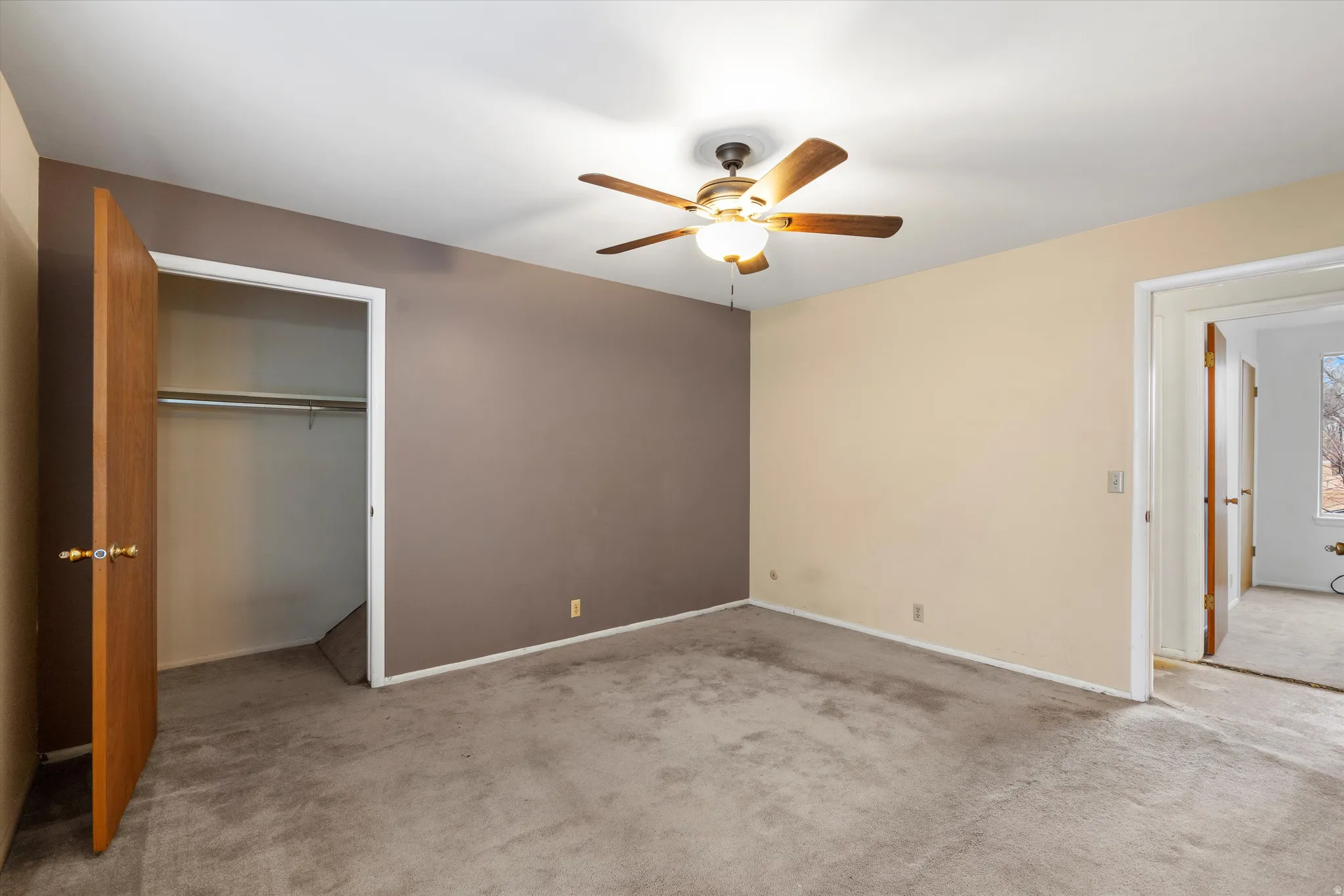 Unfurnished bedroom with a closet, carpet, and ceiling fan