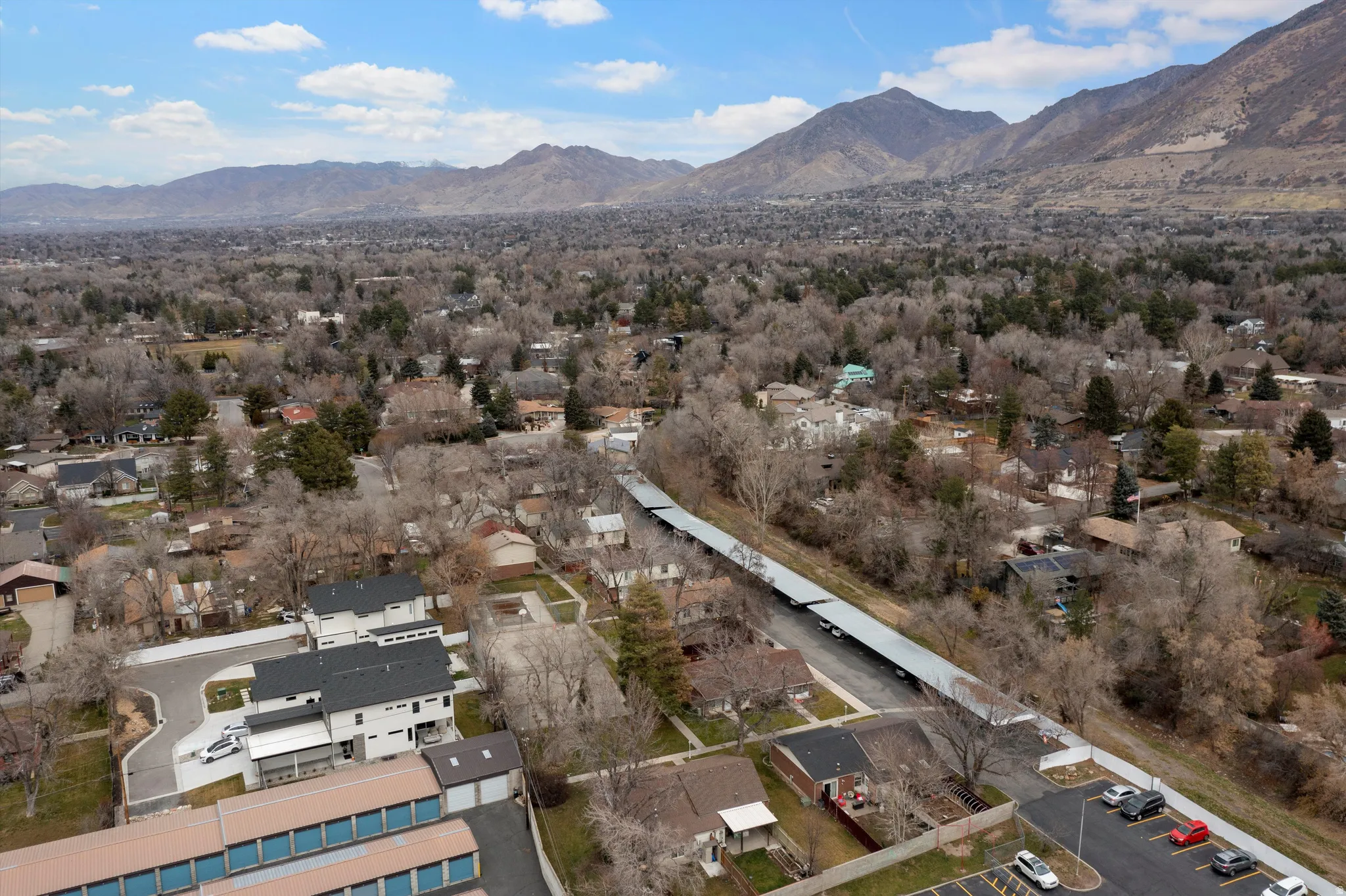 Aerial view of property and surrounding area with mountains and nearby suburban area